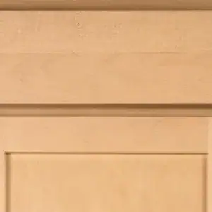 Close-up of a light wood cabinet door with detailed craftsmanship.