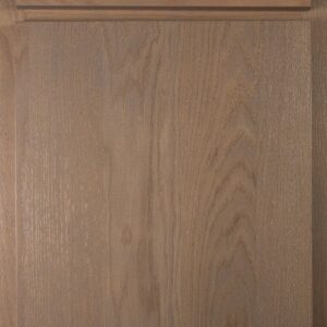 Close-up of natural wood cabinet door with drawer above.